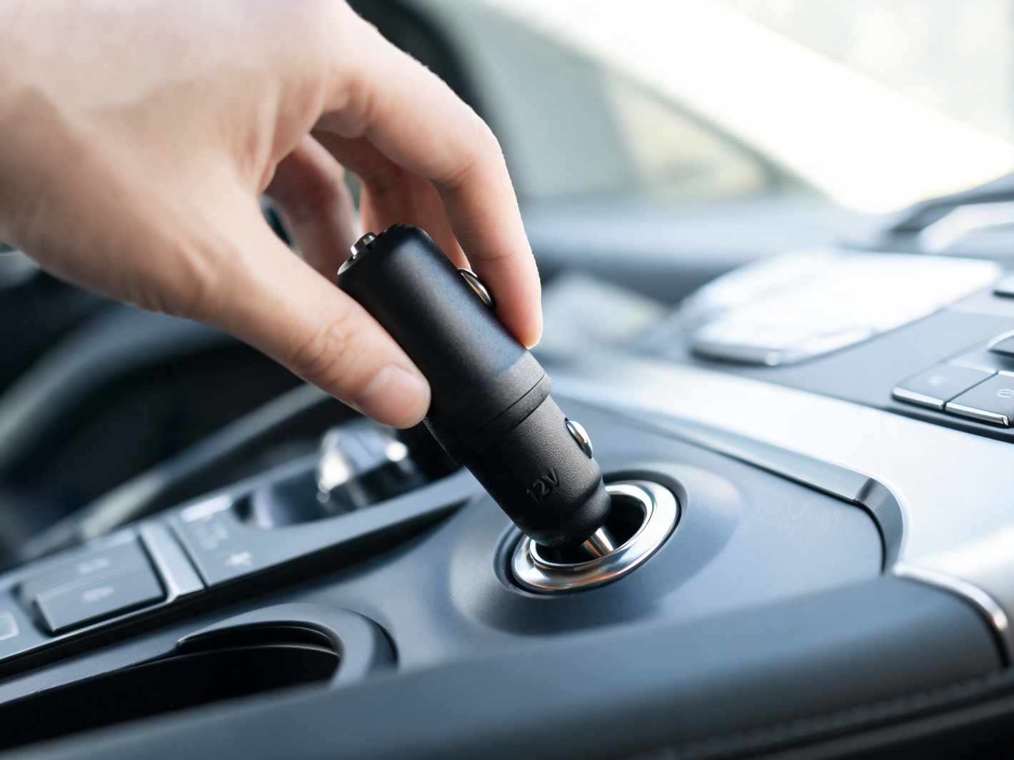 Plugging the CarPlay Pro 12V charger into the car's cigarette lighter socket
